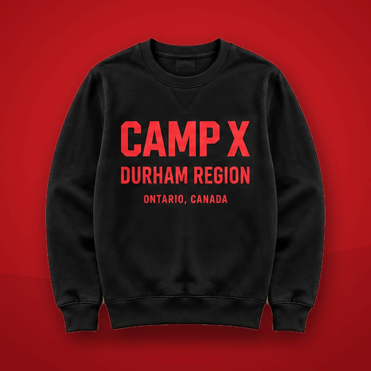 Camp X Durham Region Red Print Crewneck Sweater: black crewneck sweater with red CAMP X Durham Region print on a red background