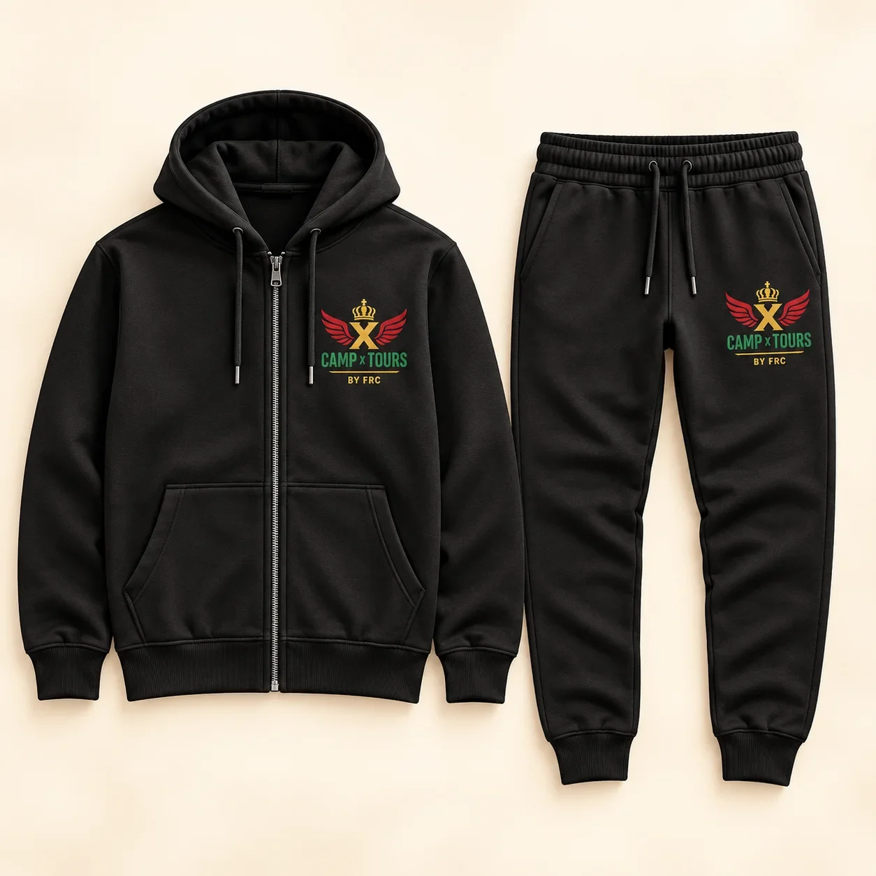 Black zip-up hoodie and matching joggers, each with the Camp X Tours by FRC emblem of a gold crown, gold X, red wings and green lettering